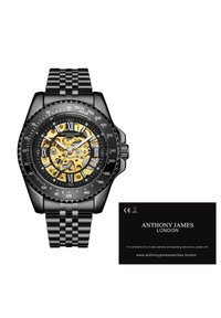 Zwarte roestvrijstalen horloge met een geweven armband, transparante gele en zwarte wijzerplaat met Romeinse cijfers en een roterende bezel.