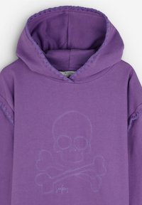 Un sweat à capuche violet arborant un design de crâne et de tibias brodé dans une teinte plus claire. L'ourlet et la capuche présentent des détails de couture contrastants.