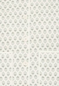 Bílá látka s opakujícím se květinovým vzorem v zelené a hnědé barvě. Obsahuje dva knoflíky, kapesníček na hrudi a kontrastní šití.