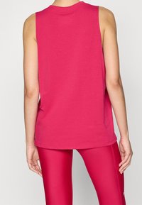 Top sin mangas de tela de algodón de color rosa brillante, con un escote redondo y un corte relajado. La parte posterior es lisa, sin elementos de diseño adicionales.