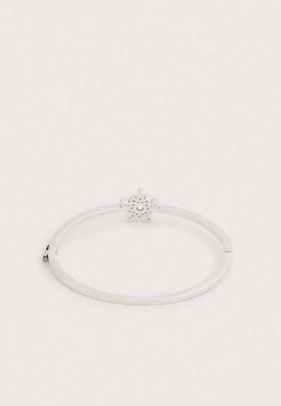 Hõbedast käevõru geomeetrilise lillemotiiviga keskel, millel on sile viimistlus ja tekstureeritud rihm.