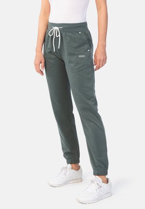 Dunkelgrüne Jogginghosen mit einem verstellbaren Bund, elastischen Bündchen und Seitentaschen. Mit kleinem weißem Logo am linken Oberschenkel.