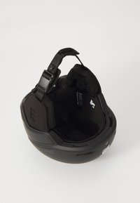 Svart sports hjelm med et slankt design, justerbart stropp, indre polstring og ventilasjonsporter. Har en teksturert, komfortabel fôr.