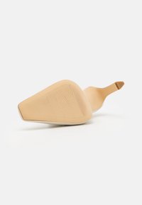 Nu nude aukštakulniai batai su smailiu pirštu, tekstūruota padu geresniam sukibimui ir plona kulkšnies juostele. Lygus kūnas suteikia elegantišką išvaizdą.