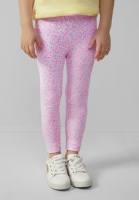 Roze bloemenpatroon leggings van stretchstof. Het patroon bevat kleine bloemen tegen een lichtgrijze achtergrond.