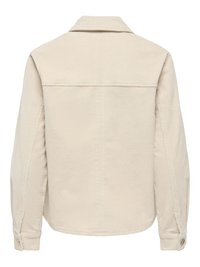 Veste beige en velours côtelé à manches longues avec poignets boutonnés et une couture droite sur le yoke du haut du dos.