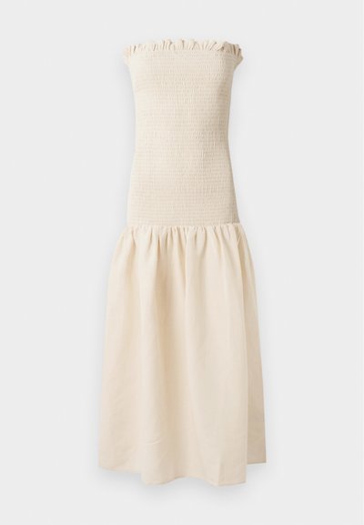 Trägerloses beiges Kleid mit einem gerafften Oberteil und einem gerafften, fließenden Rock. Der Stoff wirkt leicht und hat eine glatte Textur.