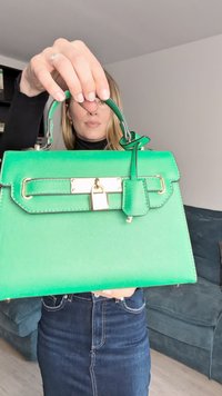 Élénkzöld kézitáska strukturált kialakítással, texturált felülettel, arany színű fémalkatrészekkel és lakat részlettel. Felső fogantyúval és levehető pánttal rendelkezik.