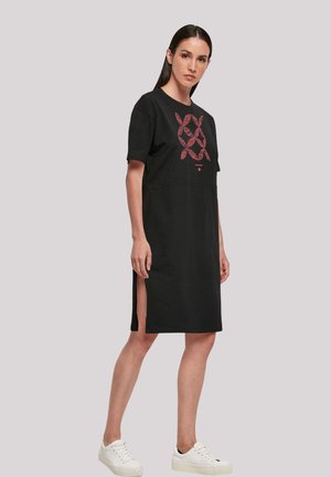 Schwarzes Baumwollkleid mit kurzen Ärmeln und Rundhalsausschnitt. Verfügt über ein rotes Grafikdesign und seitliche Schlitze. Getragen mit weißen Turnschuhen.