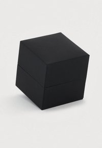 Κλειστό μαύρο τετράγωνο κουτί κοσμημάτων με ελαφρώς υφή στην επιφάνεια σε λευκό φόντο.