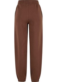 Bruine sportbroek van zacht materiaal, met een elastische tailleband, zijzakken en taps toelopende enkels met elastische boorden.