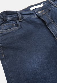 Mörkblå denimjeans med kontrasterande sömmar, en framknapp och dragkedja, samt en klassisk femfickorsdesign.