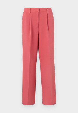 Pantalon taille haute sur mesure couleur corail rose, avec plis sur le devant, passants pour ceinture, et jambes droites, sur un fond clair uni.