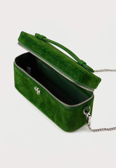 Zelená kordurová taška so zipsom, vnútorné podšívku v zodpovedajúcej zelenej farbe a strieborný reťazový popruh. Obsahuje dekoratívny detail na zapínaní.