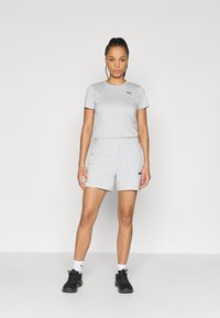 Σετ γκρι βαμβακερό μπλουζάκι και σορτς, με μαύρο λογότυπο στο στήθος και στα σορτς. Περιλαμβάνει μαύρα αθλητικά παπούτσια και κάλτσες αστραγάλου.