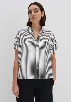 Zwart-witte gestreepte blouse met korte mouwen, knoopsluiting aan de voorkant en kraag. Zachte stof met een losse pasvorm en zijsplitten aan de onderkant.