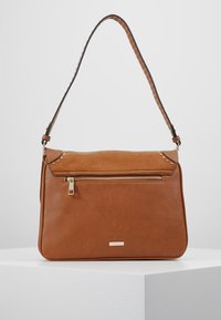 Hnědá kožená taška přes rameno s texturovaným povrchem, se zipovou kapsou na přední straně a dekorativními nýty blízko horní části. Popruh s akcentními stehy.