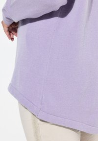 Maglione lavanda con tessuto a maglia testurizzato, caratterizzato da un orlo arrotondato e maniche lunghe. I dettagli delle cuciture laterali aggiungono interesse visivo.