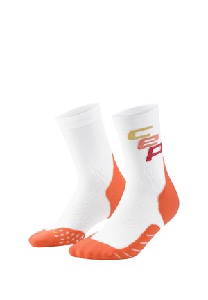 Paar weiße Crew-Socken mit orangen Fersen, Zehen und Sohlen-Griffmustern, mit stilisierten Buchstaben in Gelb, Orange und Rot an den Seiten.