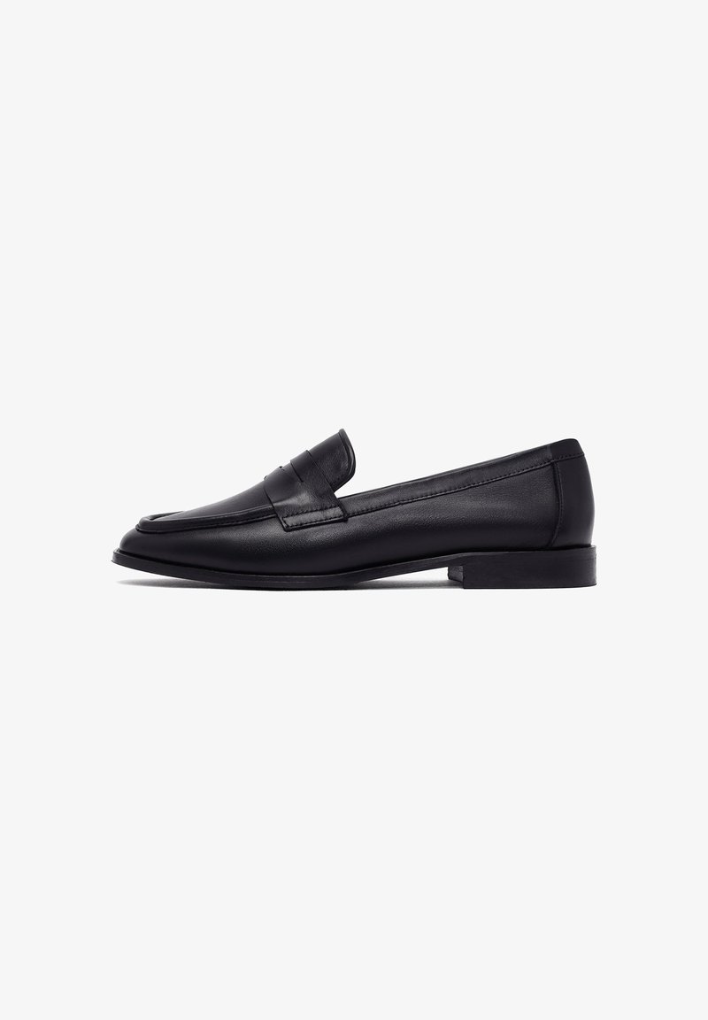 Zwarte leren heren penny loafers met een lage hak, gestikte details en een instapontwerp, weergegeven op een witte achtergrond.