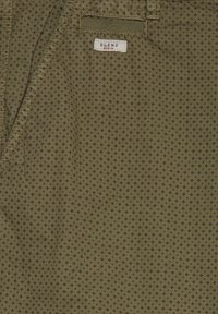 Olive green fabric with small black diamond pattern and a white label reading "BLEND DENIM" stitched near a pocket opening.