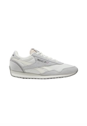 Sneaker Reebok low-top bianco e grigio chiaro con sovrapposizioni in camoscio, chiusura con lacci e suola in gomma, mostrato di profilo laterale.
