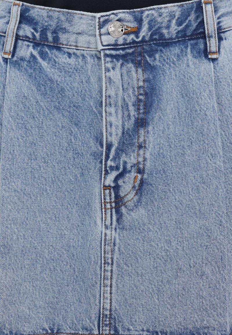 Hellblaues Jeansrock mit gepresster Textur, gefertigt mit einem Knopfverschluss vorne, Gürtelschlaufen und kontrastierendem orangem Stich entlang der Nähte.