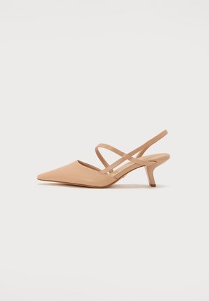 Zapato slingback beige de punta afilada con finas correas cruzadas y tacón bajo tipo kitten.