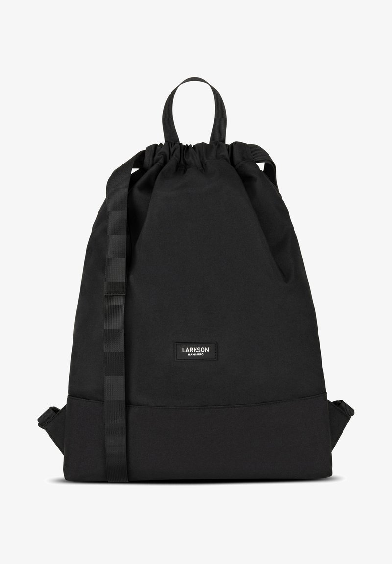 Musta narukassikäyttöinen reppu kankaasta, jossa on kestävä yläkahva, säädettävät hihnat ja brändilogo alaosassa.