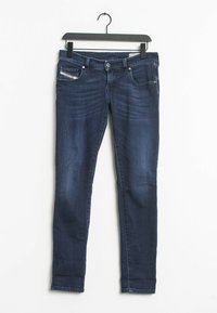 Vaqueros ajustados de color azul oscuro, fabricados en denim, con bolsillos frontales y un sutil patrón de lavado. Los vaqueros cuentan con un diseño clásico de cinco bolsillos.