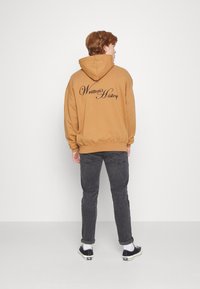 Pegador WRITTEN HISTORY OVERSIZED HOODIE UNISEX - Sweatshirt com capuz - washed ginger