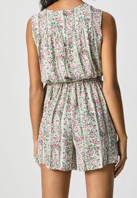 Květinový overal v světle zelené barvě, s růžovými květy a vertikálními pruhy. Elastický pas s volným střihem šortek.