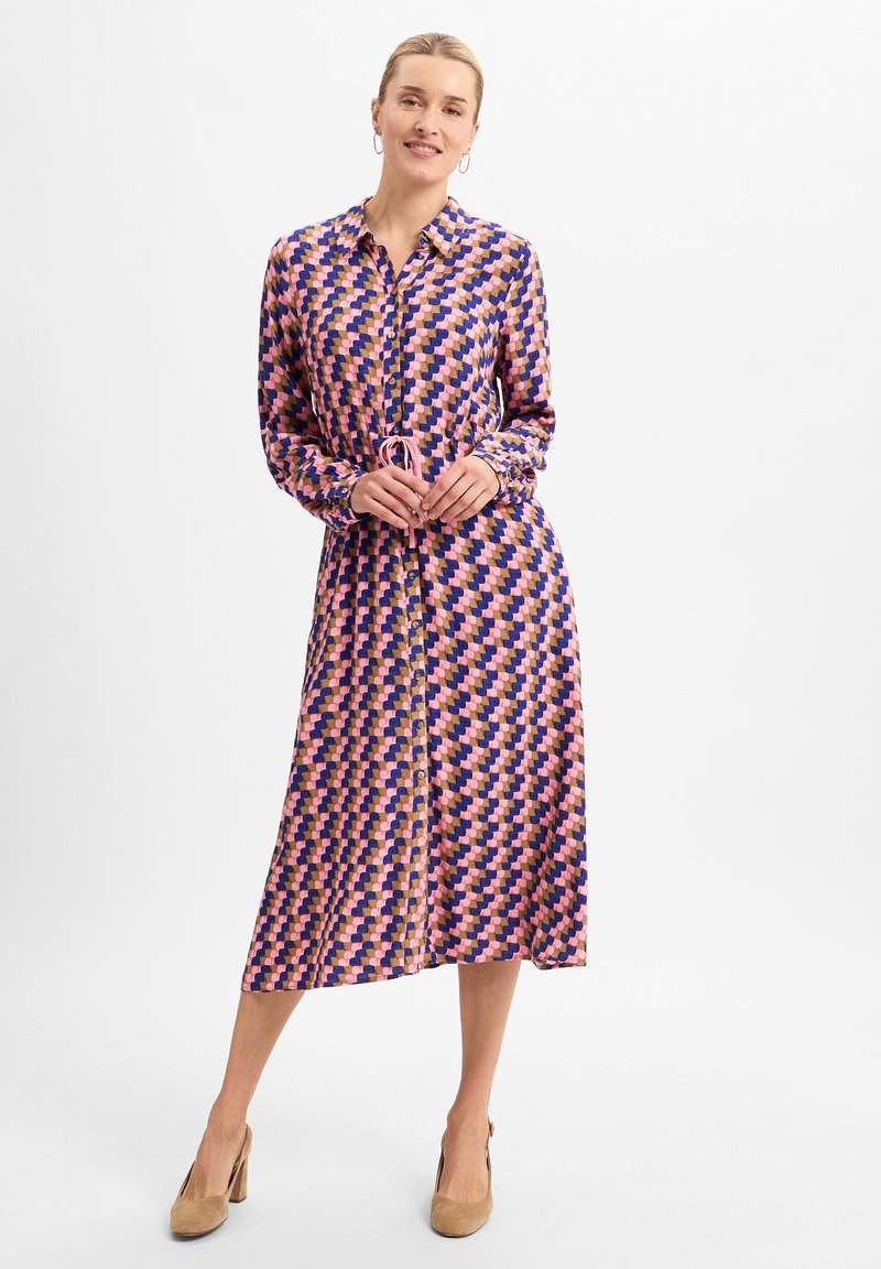 Long-sleeve, button-up dress in a geometric pattern of pink, purple, and navy blue. Features a cinched waist and smooth fabric.