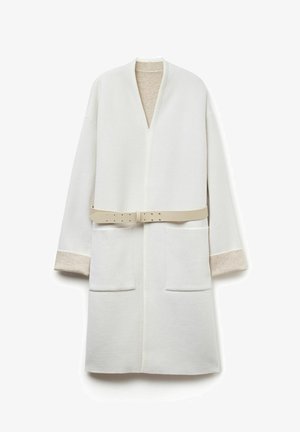 Biały, długi szlafrok z miękkiego materiału. Posiada dekolt w serek, dwie przednie kieszenie oraz odpinany jasnobeżowy pasek. Akcenty na rękawach.