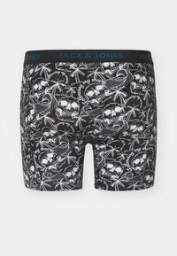 Culotte nere con un motivo ripetuto di teschi e palme bianche, dotate di un elastico blu con l'etichetta "JACK & JONES."