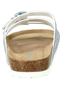 Sandal slide con una soletta in sughero e una suola piatta bianca. Cinghie regolabili in tonalità argento con una finitura testurizzata. Design pulito e minimalista.