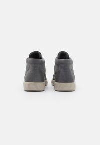 Scarpe alla caviglia in suede grigio con suola in gomma testurizzata, caratterizzate da una punta rotonda e design minimalista. L'altezza del tacco è bassa.