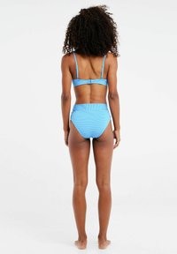 Plavi bikini set sa prugama koji se sastoji od bralette gornjeg dijela s podesivim trakama i visokog struka donjih dijelova s širokim pojasom. Glatka tekstura.