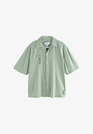 Korte mouwen, overhemd met kraag in lichte groene stof met knopen. Bevat geborduurde tekst en een klein ontwerp op de linkerkant van de borst en de zoom.