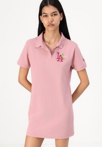 Rosa polo t-shirt med krage, korta ärmar och broderad LA-logotyp samt blommig detalj på bröstet. Tillverkad av mjukt, slätt bomullstyg.