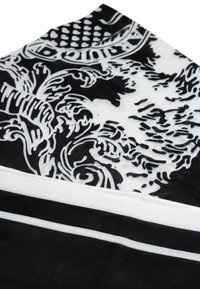 Schwarz-weiß gemusteter Stoff mit ausgeklügelten floralen Designs, glatter Textur und dünnen weißen Streifen entlang der Ränder.