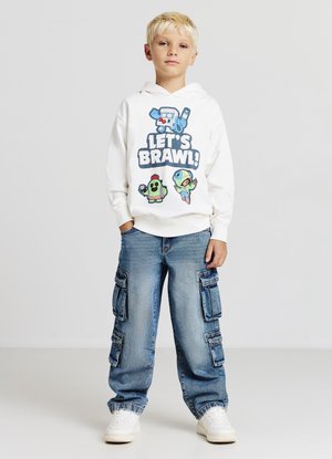 Felpa bianca con grafica "LET'S BRAWL!" e personaggi dei cartoni, abbinata a pantaloni cargo in denim blu larghi con tasche multiple.