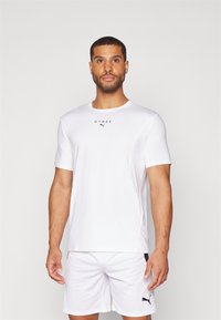 Hvit idretts T-skjorte med korte ermer og rund hals. "HYROX" logo og liten Puma-logo i svart foran, glatt stoff.