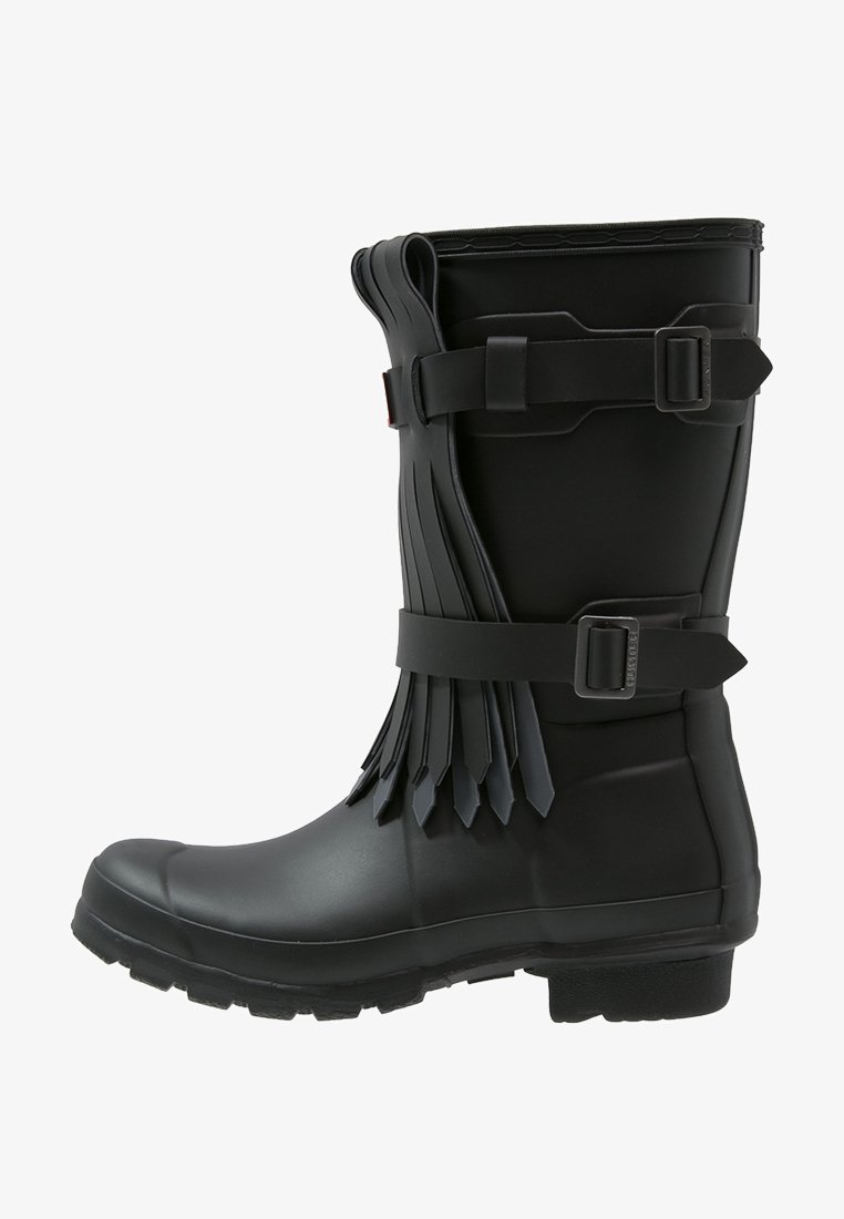 Czarna gumowa botka sięgająca do połowy łydki z paskami z klamrami i warstwowym frędzlem po boku, wyposażona w wytrzymałą podeszwę i zaokrąglony nosek.