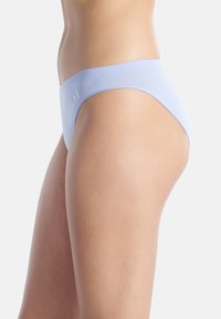 Bikini underwear senza cuciture di un delicato colore viola, con una texture liscia, caratterizzato da un design a vita bassa e un discreto logo sul girovita.