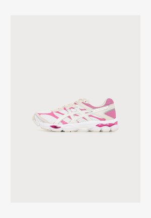 Chaussure de sport blanche et rose avec des panneaux en mesh, une semelle coussinée et un design à lacets, vue de côté sur un fond uni.