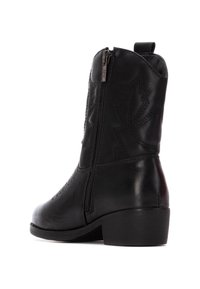 Botas de cowboy de cuero negro con detalles de costura, punta afilada, tacón bajo en bloque, cremallera lateral y una lengüeta en la parte superior para una fácil colocación.