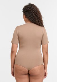 Bodysuit in beige, mit kurzen Ärmeln, eng anliegendem Design, glatter Textur. Besitzt einen hohen Rücken und einen minimalen Rückenausschnitt.