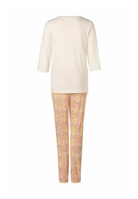 Zweiteiliger Look mit einem cremigen Oberteil mit drei Viertelärmel und gemusterten Hosen in Gelb, Pink und Rot mit einem dekorativen Design.