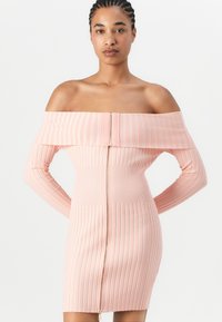 Off-shoulder rosa ribbesatt kjole med lange ermer, tettsittende fasong og frontglidelås. Glatt tekstur med vertikale striper gjennom hele.